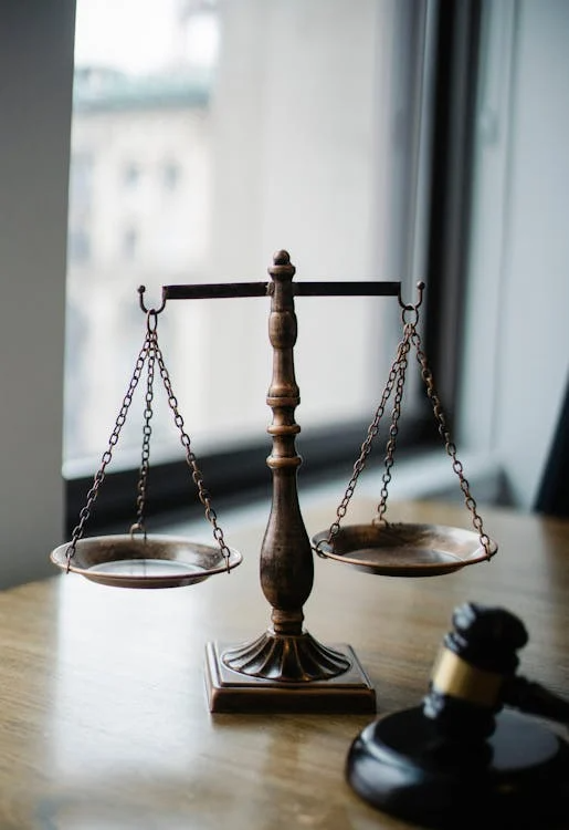 a judge's scale and gavel placed on a wooden table