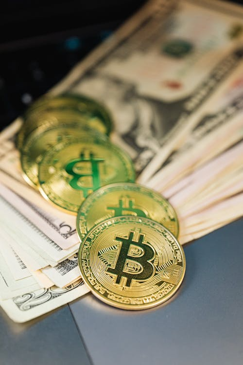 Close-up of Bitcoin coins placed next to paper currency