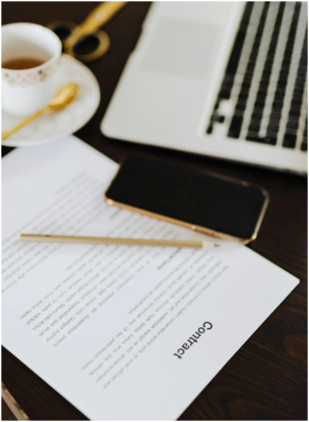 An image of a contract beside a laptop