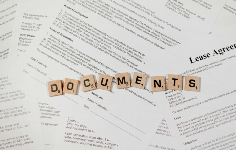 This image shows the word ‘documents’ spelled with Scrabble tiles placed on top of documents.
