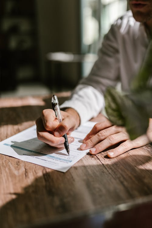 An image of a man signing a document