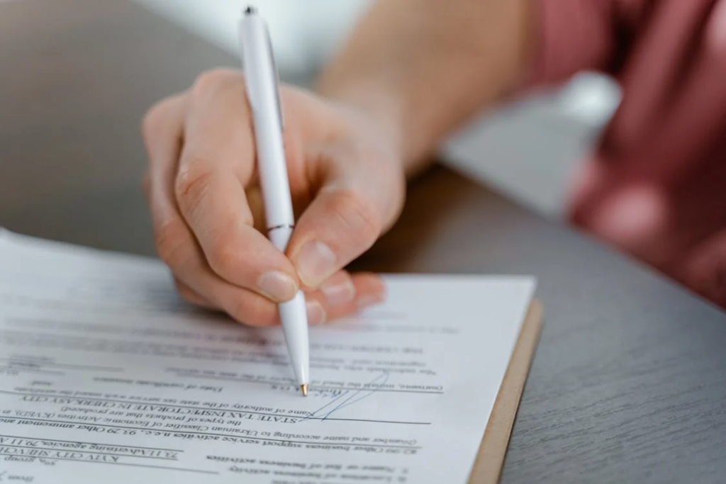 An image of a person signing a document