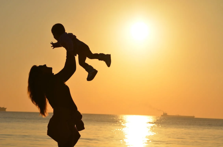 a mother playing with her baby at the beach