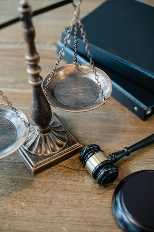 Scales of justice gavel and law books on a wooden surface