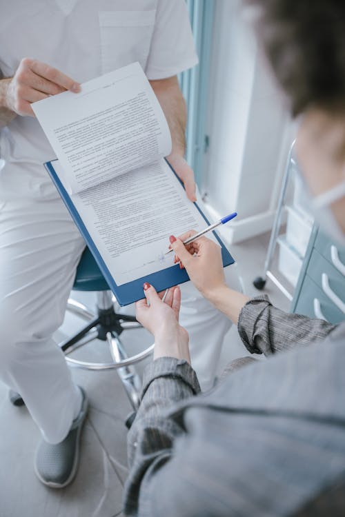 Medical consent forms stacked on a clinic registration counter under bright lighting