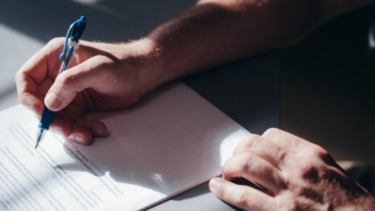 An image of a person signing a document