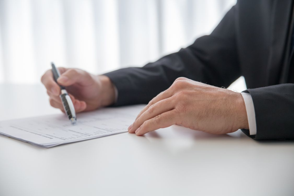 An image of a person signing a document