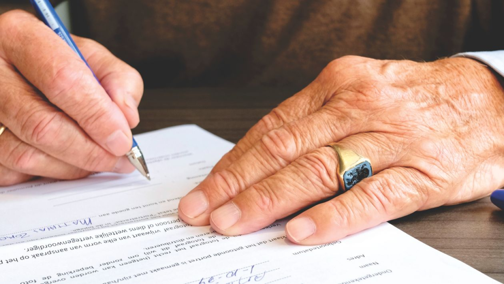An image of a person signing a document