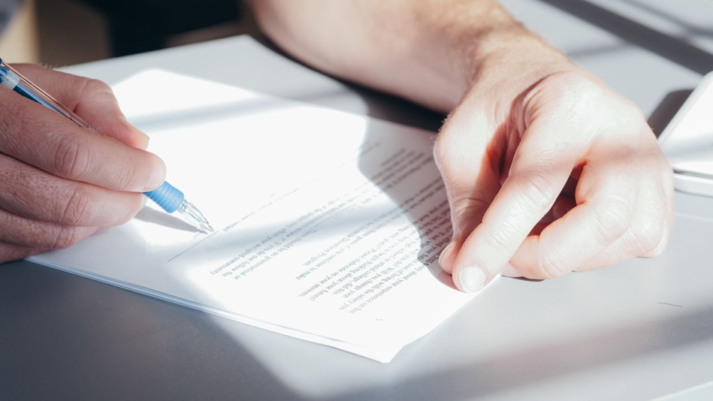 An image of a person signing a document