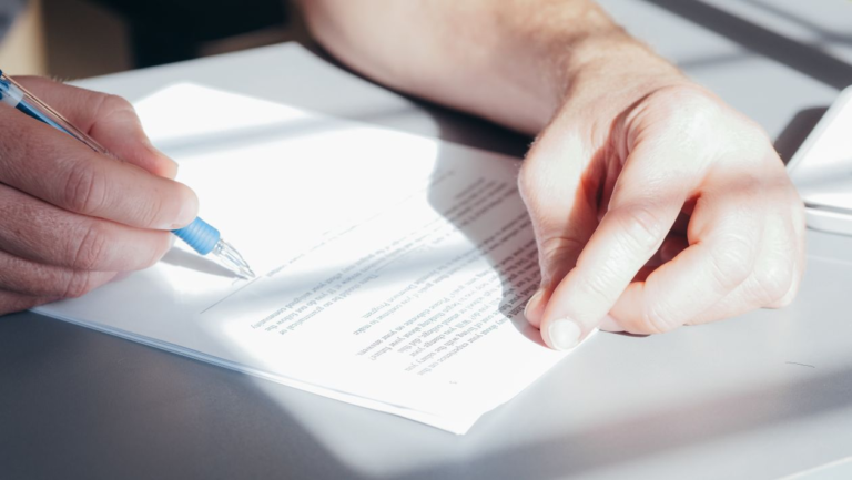 An image of a person signing a document
