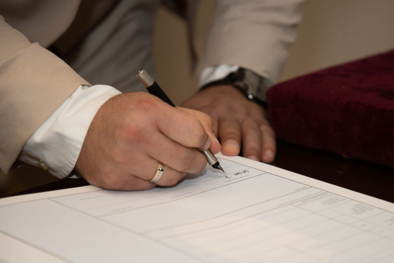 An image of a person signing a document