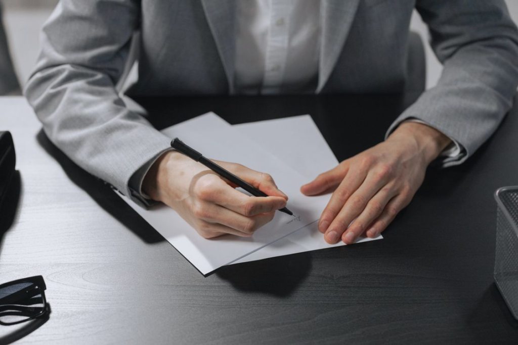 An image of a person writing something on paper
