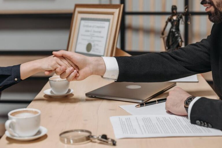 An image of people shaking hands over a table