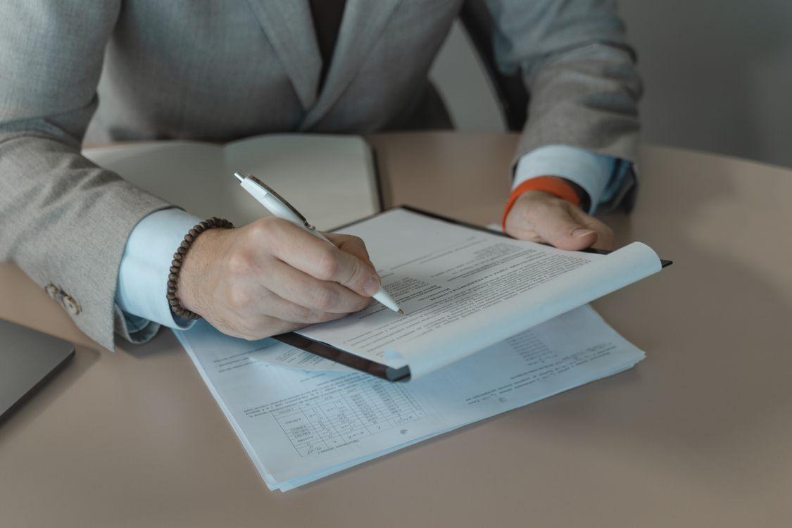 An image of a man signing a document
