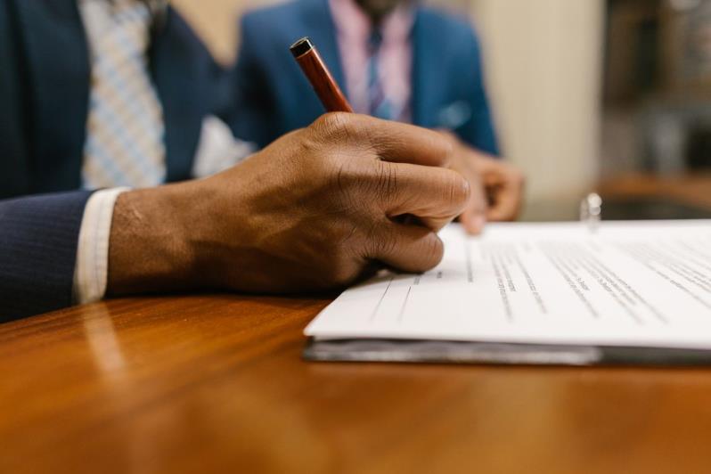An image of a person signing a document