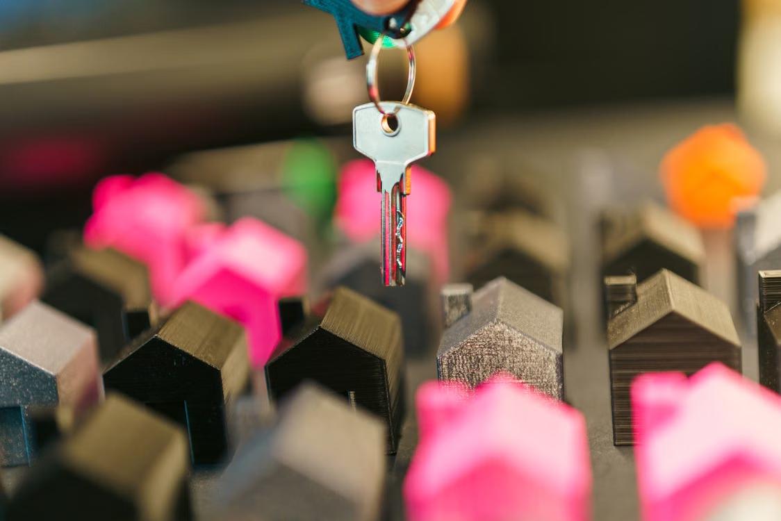 An image of a key over miniature wooden houses