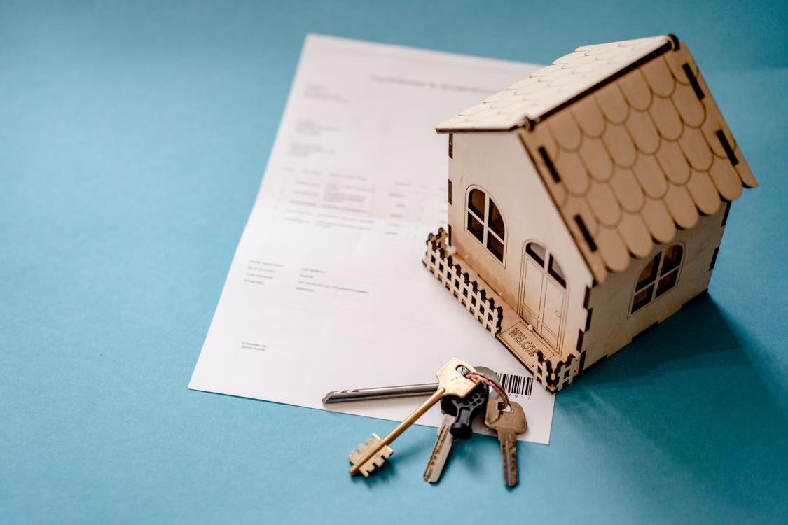 An image of a miniature wooden house and keys