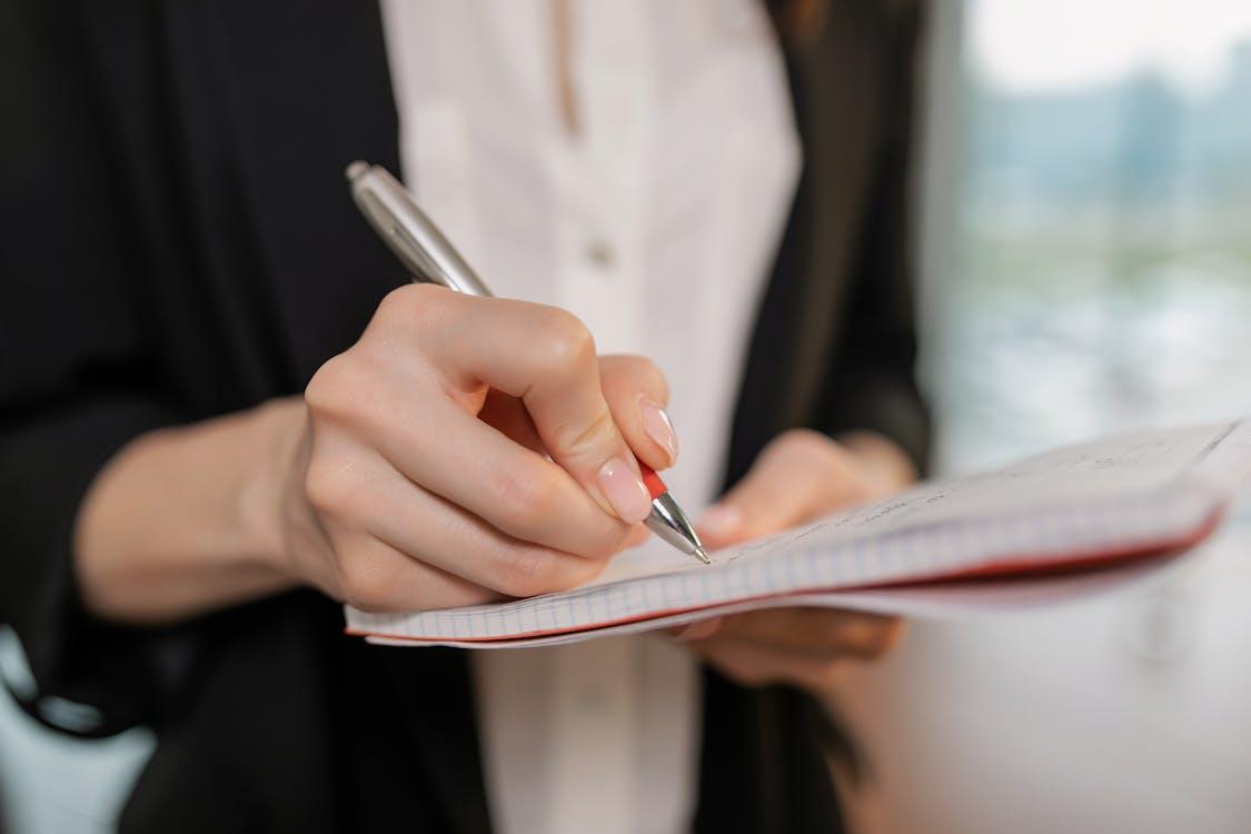 An image of a person writing in their notebook