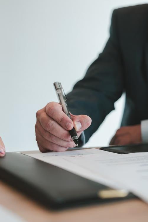 An image of a person signing a document