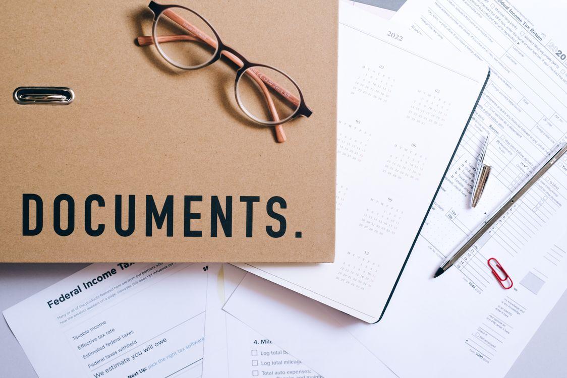Document folder with eyeglasses and financial papers on a desk
