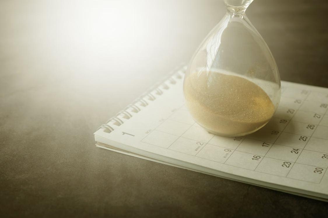 Sandglass resting on a calendar