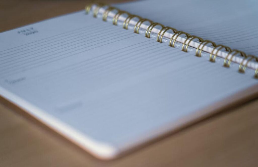 Open spiral notebook on a wooden table
