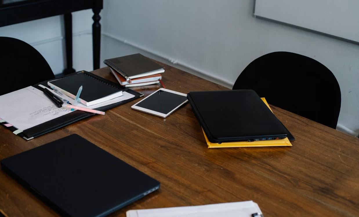 Planners and devices arranged on a wooden office table