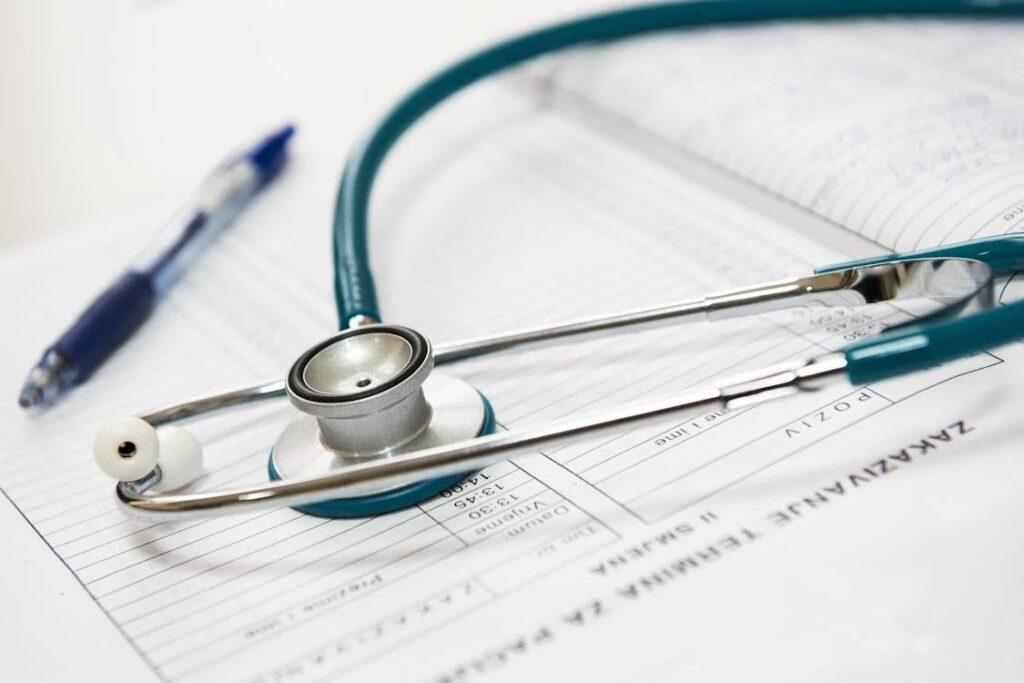 Stethoscope and blue pen resting on a medical form