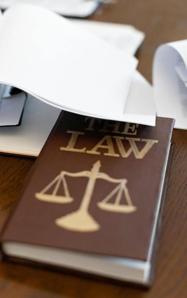 Law book with a scales of justice emblem on a wooden desk