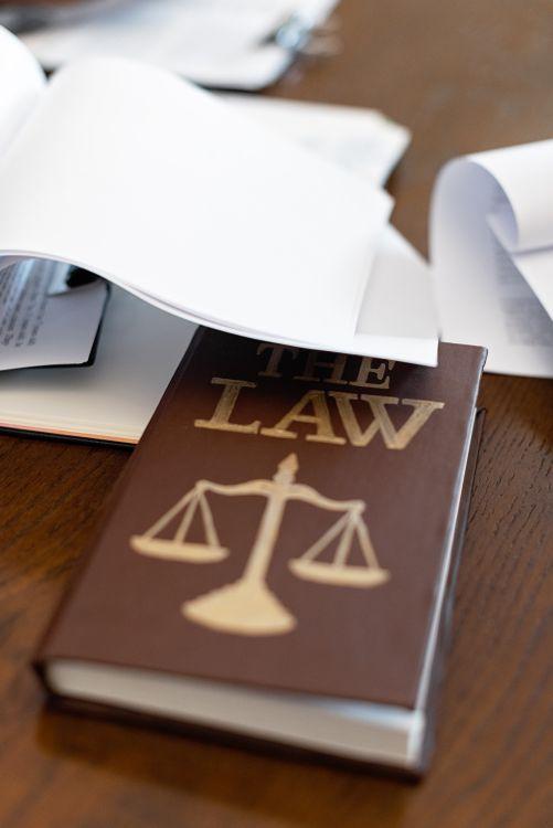 Law book with a scales of justice emblem on a wooden desk